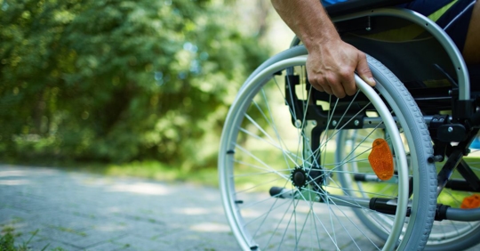 close up image of a person holding a wheel on a wheelchair
