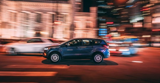 cars speeding through the street at night