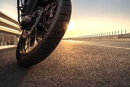 motorcycle wheel with sun in background
