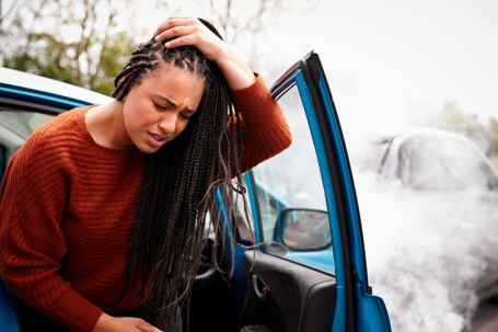 Woman holding head after car accident