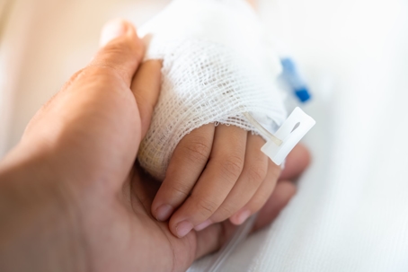 holding child's hand in hospital